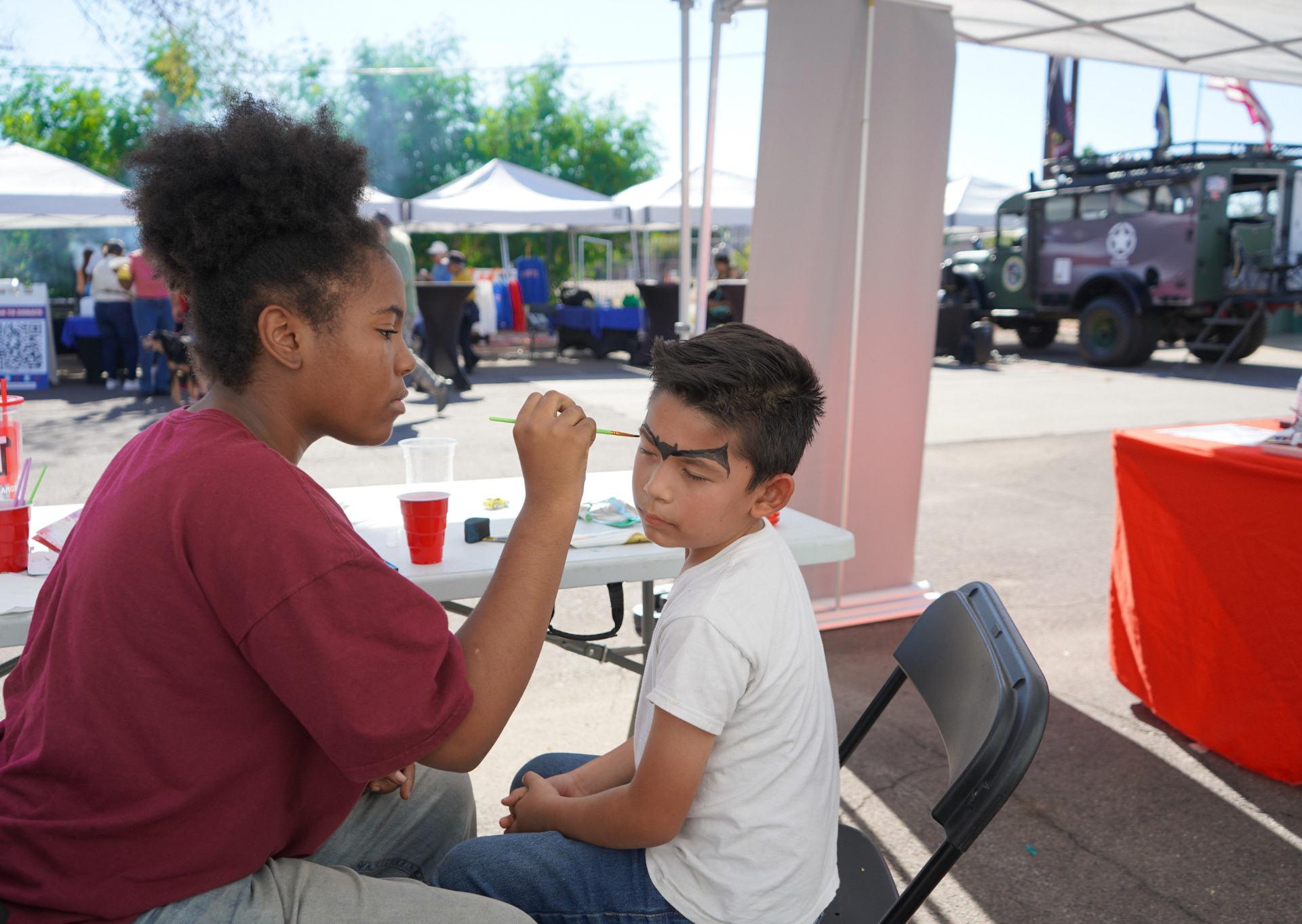 A child getting their face painted at a community event