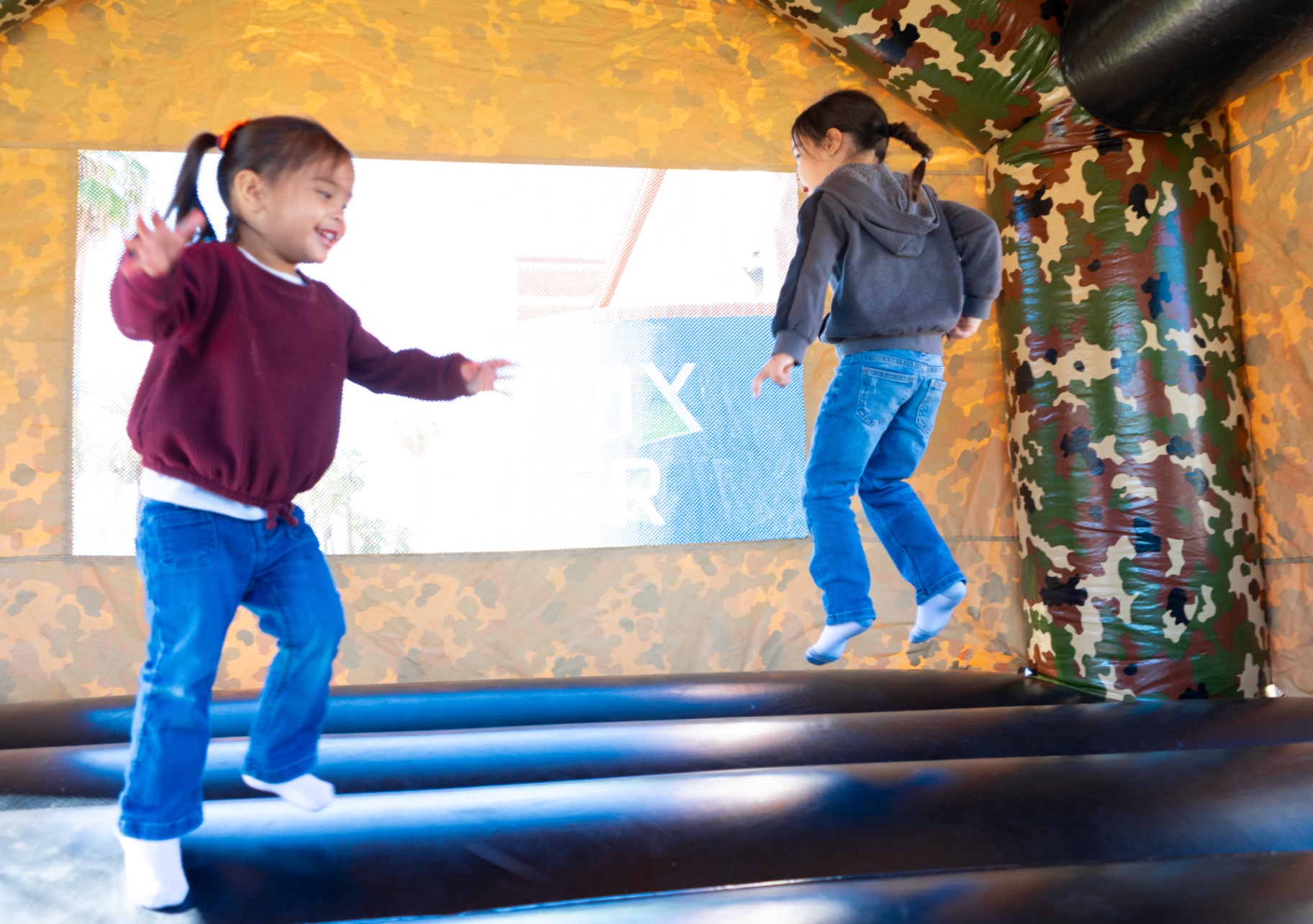 Kids jumping in a bounce house at the community event